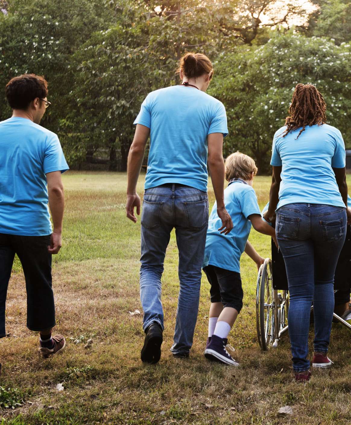 a group of people of various ages walking. they are all wearing the same t-shirt.