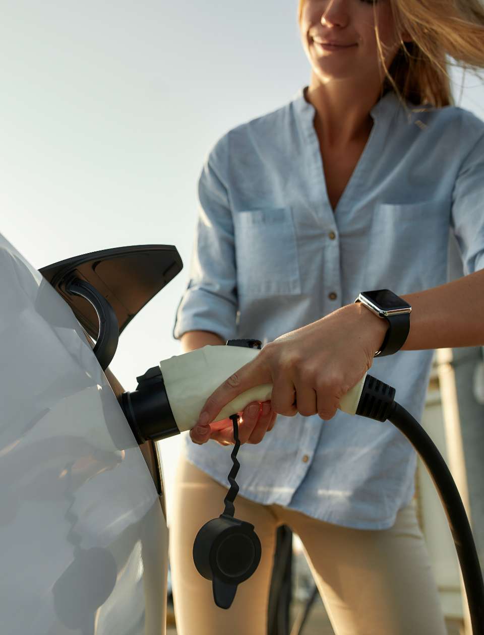 a person plugging in an electric vehicle